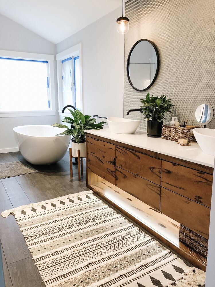 Warm wood bathroom vanity with vessel sinks and round mirrors
