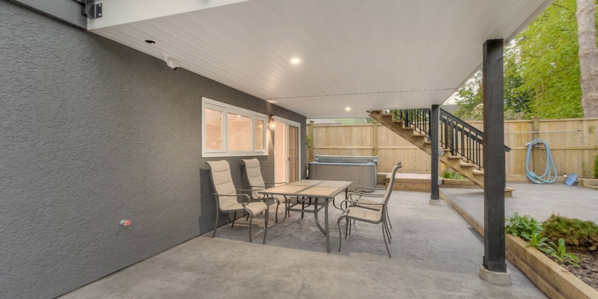 Covered patio with outdoor dining table and recessed lighting
